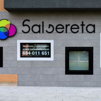 Cartel de la fachada del local y ventana con los datos de contacto