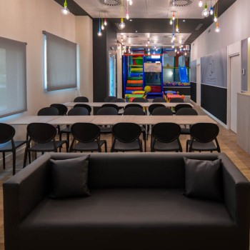 Sofá, comedor para adultos, comedor para niños y parque infantil del local multifuncional