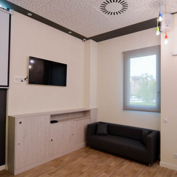 Salón del local con sofá y televisión
