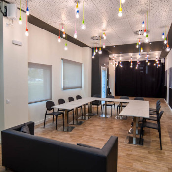 Salón del local para una tertulia o mesa redonda, con el parque infantil tapado